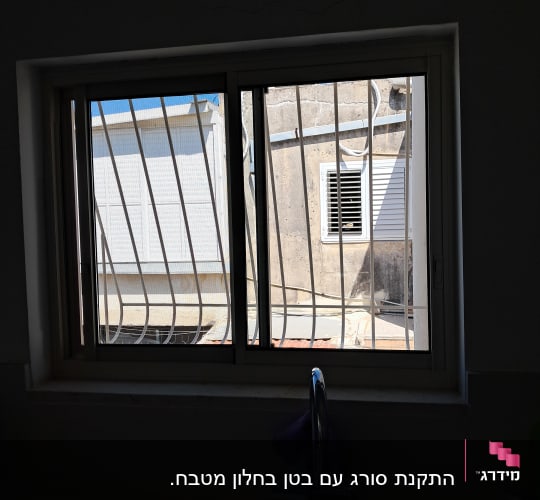 חלון עם סורגים ונוף חיצוני של בניין